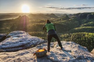 person setting up equipment on a rocky hillside