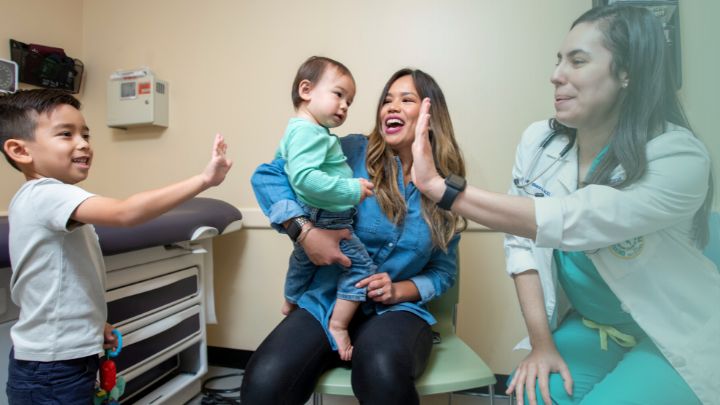 woman with two children sitting with doctor