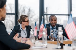 people seated at table with flags