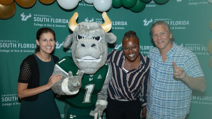 Rocky the Bull mascot with three faculty members