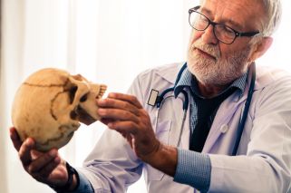 scientist holding ancient human skull