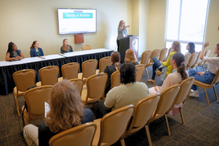 Conference panel room with students seated in chairs