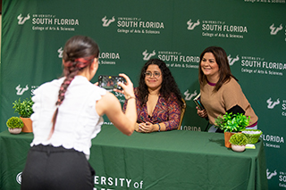 Student intern taking a photo of a guest speaker