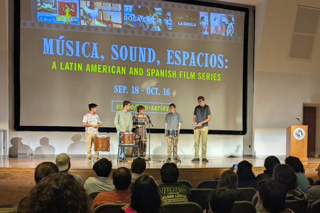 Students playing drums on stage