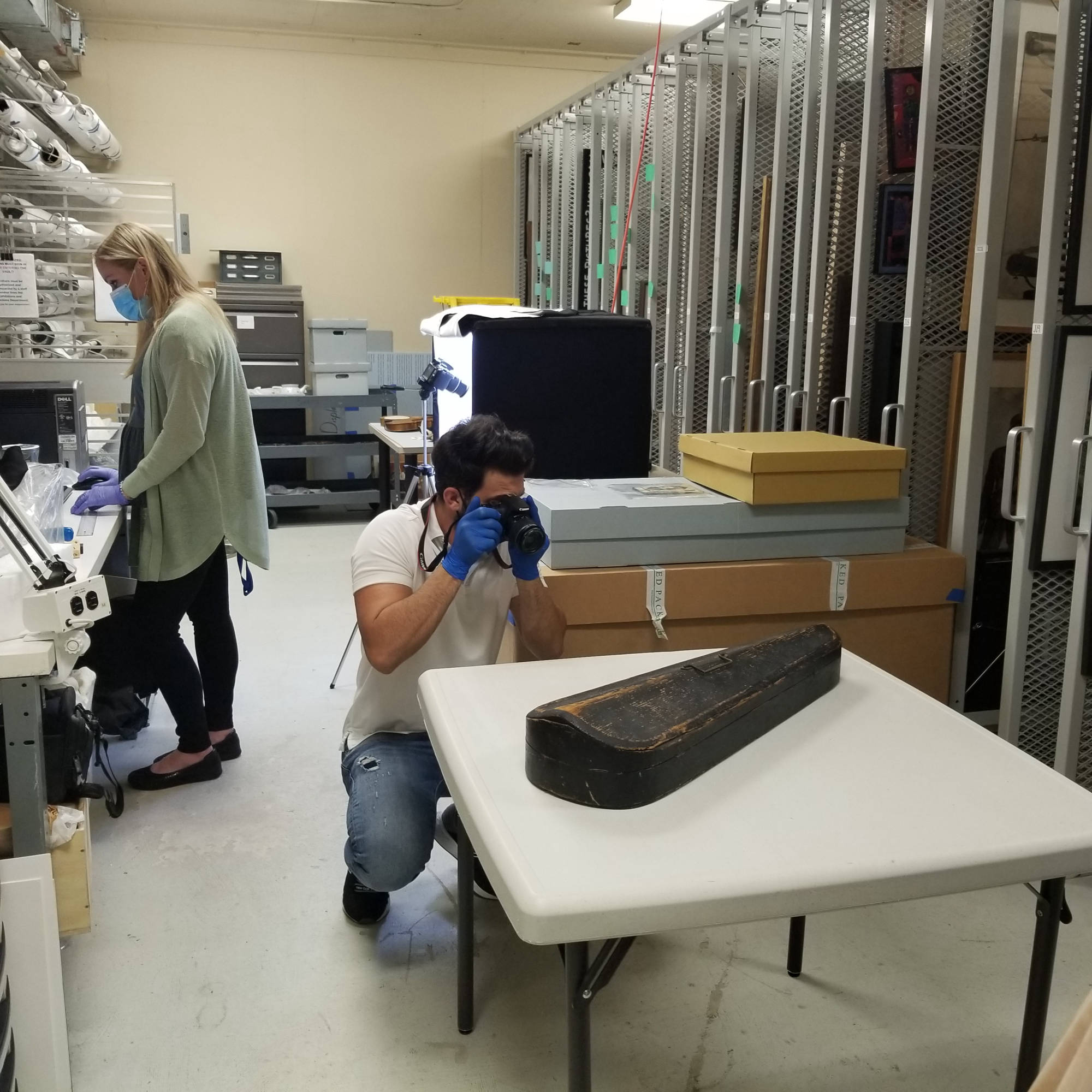 man photographing violin case