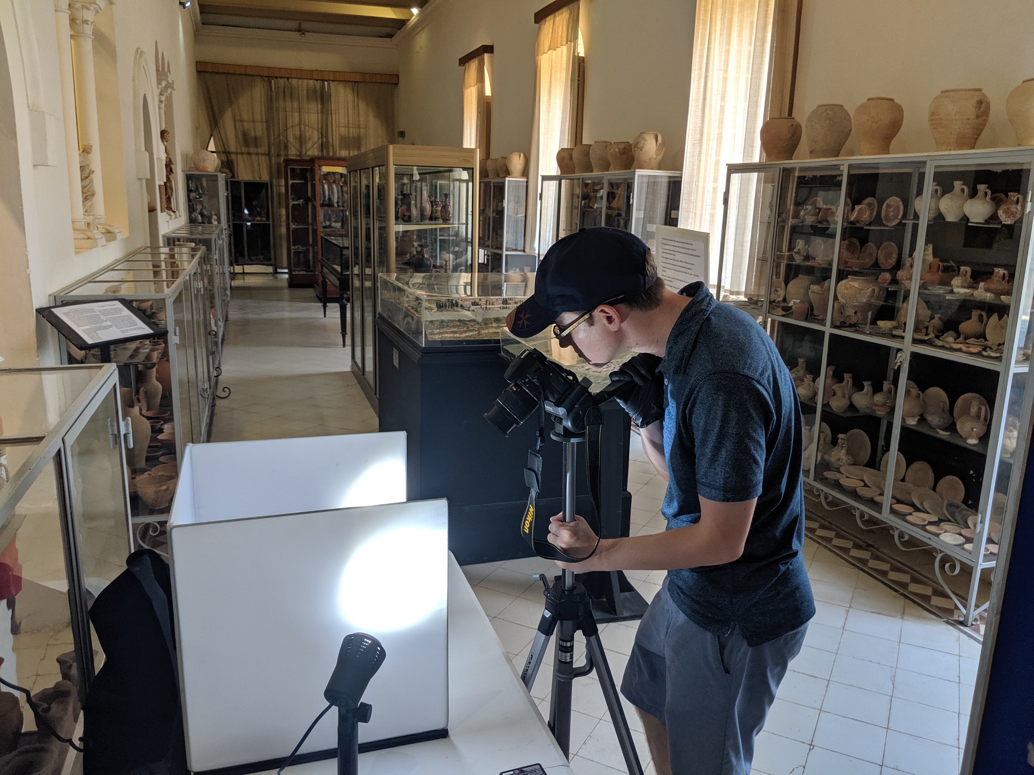 man photographing piece in a lightbox