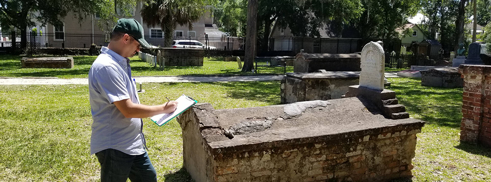 student studying tomb at Tolomato Cemetery