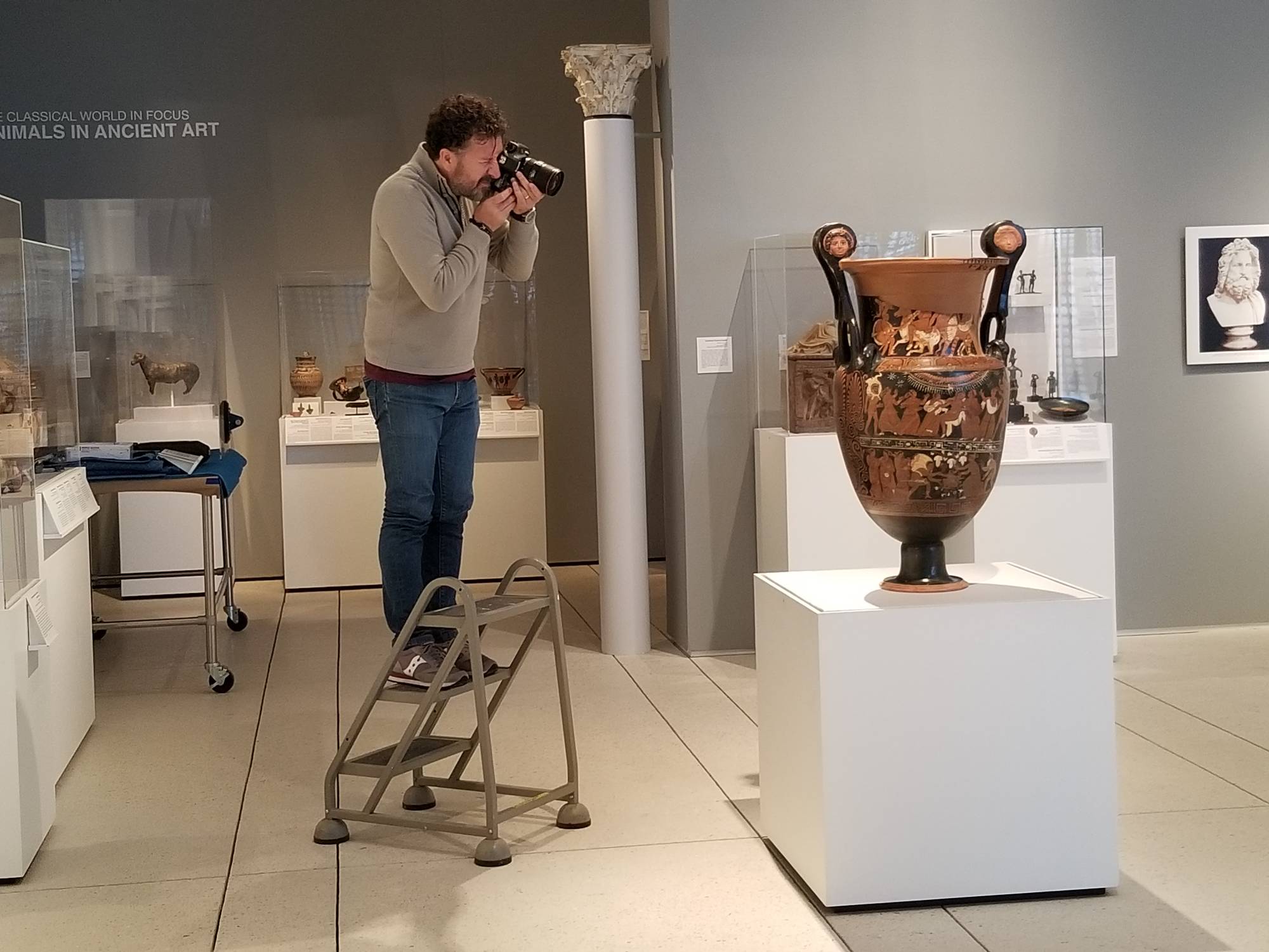 man photographing large urn