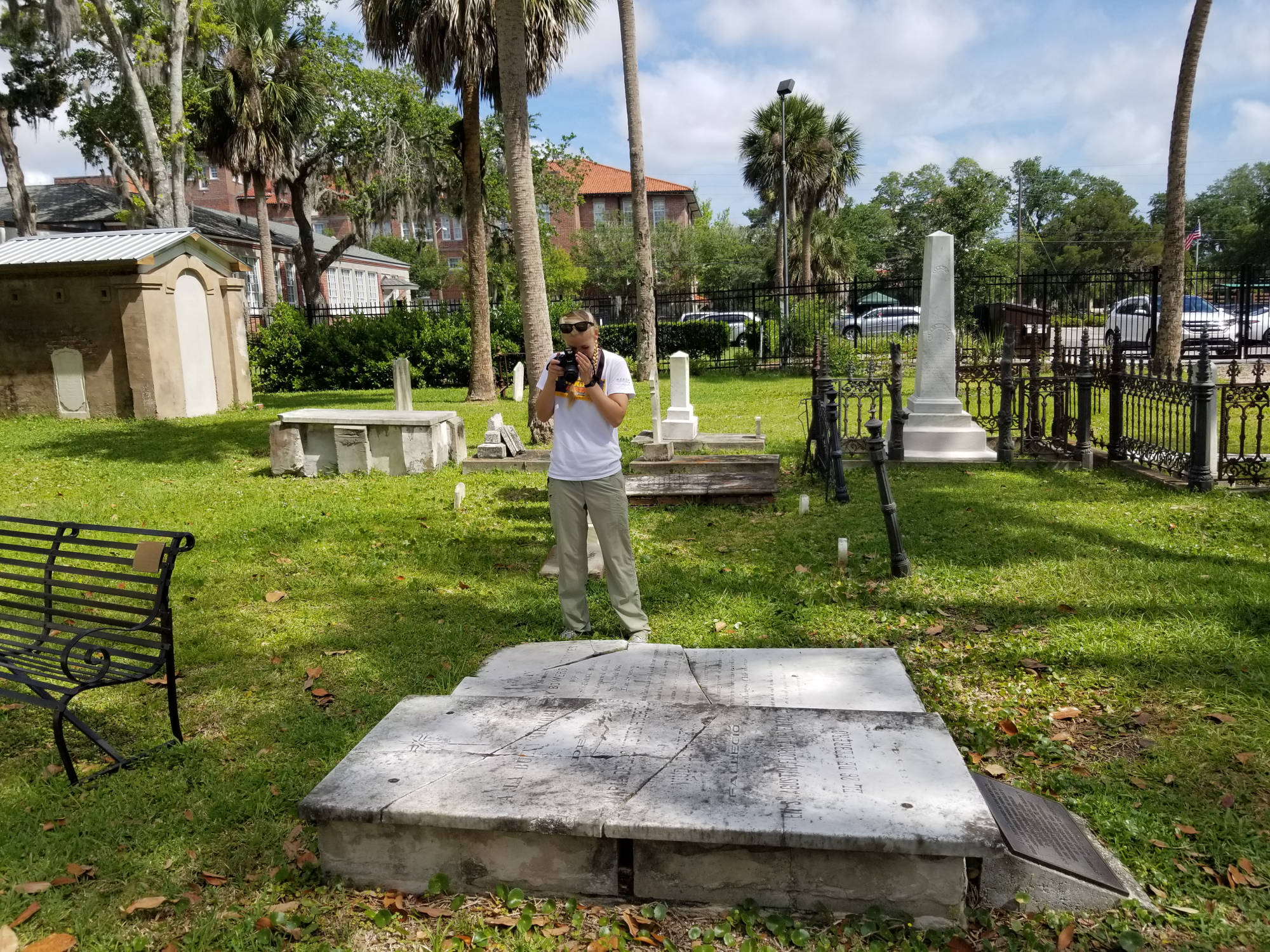 student photographing tomb in cemetery