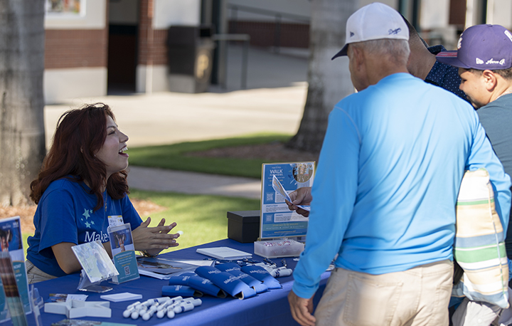 student intern working a table for Make a Wish Foundation