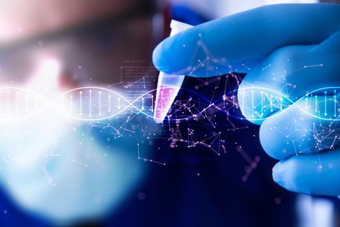 person holding test tube with double helix illustration behind