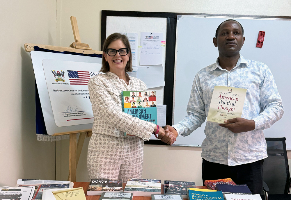 Dr. McLauchlan presents her book donation to the Center for the Study of the United States with Center director Dr. Edward Kaweesi. (Photo courtesy of Judithanne Scourfield McLauchlan)