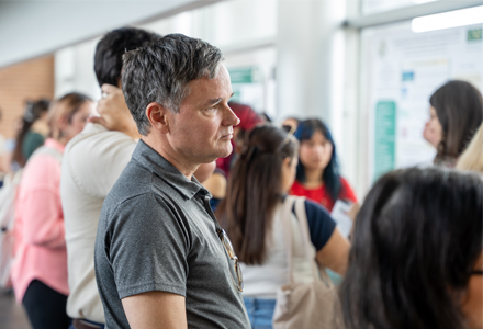 Professor Paul Atchley watching students’ poster presentations. (Photo by Dakota Galvin)