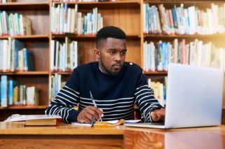 student working on laptop computer in library