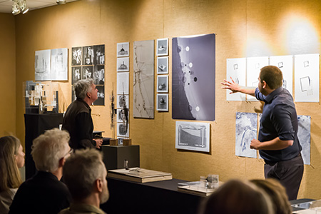 Photo of USF Architecture student presenting his thesis project in front of a review panel.