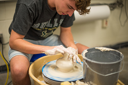 Ceramics student sculpting clay