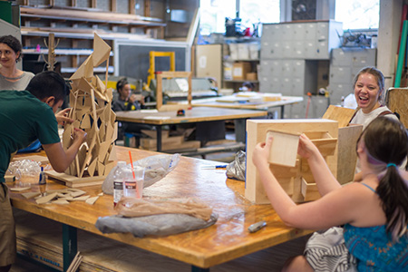 Sculpture students working on their projects inside the art woodshop.