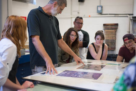 Bradlee Shanks teaches art students about printmaking.