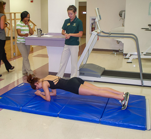 Medical students working with a dance student on physical motion practice.