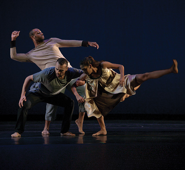 Modern dance students displaying form and technique during a group performance.