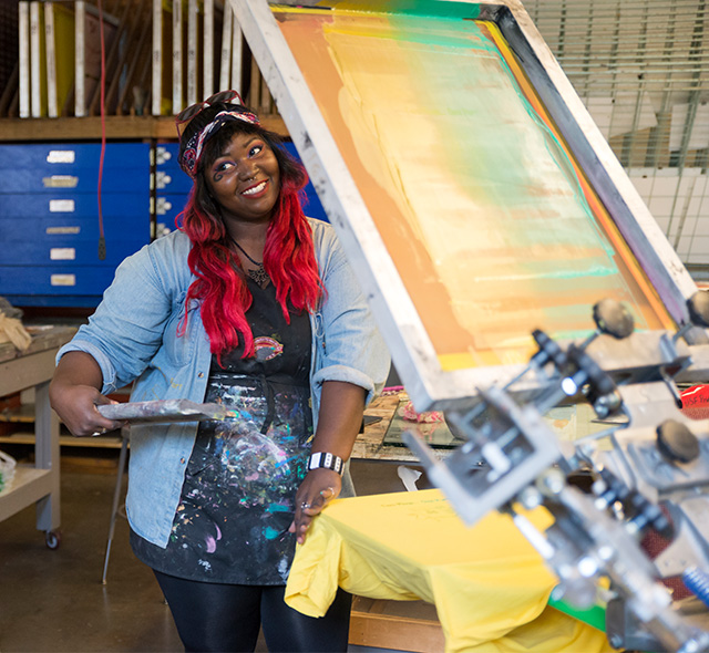 An art student setting up a t-shirt and silk screen in the printmaking studio.