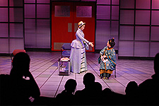 Two students on stage performing in a play.