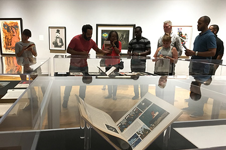 Visitors attend a curator tour of an exhibition at the USF Contemporary Museum to learn about the works on display.