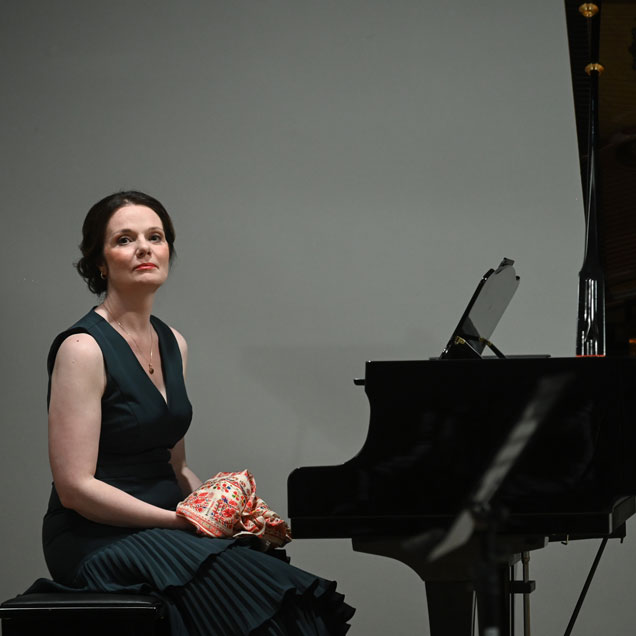 Lora Tchekoratova sitting at a piano