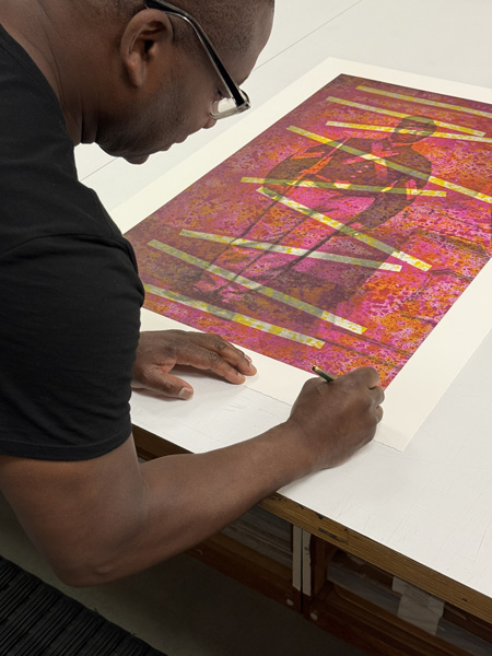 artist signing a print featuring a black civil war soldier