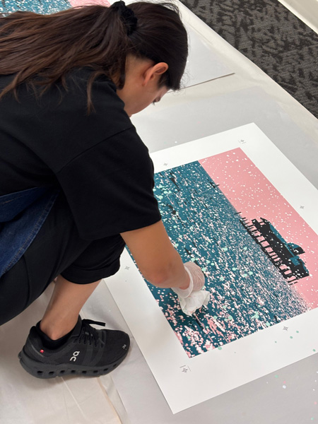 artist hand painting on teal and pink composition