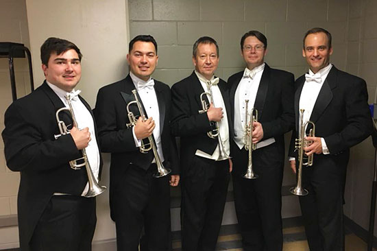 Current and former USF trumpet students and Jay Coble, professor of trumpet, pose for a photo backstage at a Florida Orchestra Concert