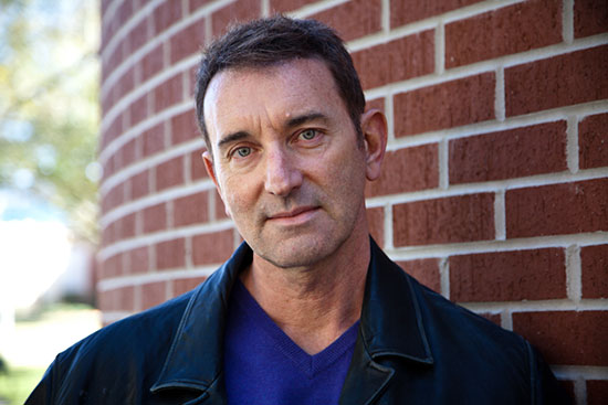 headshot of Andrew Carroll with a brick wall background