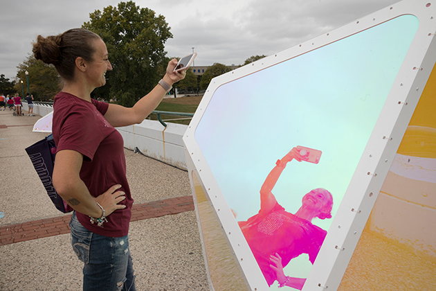 A woman takes a selfie in front of "Oscillation" in Grand Rapids, Michigan