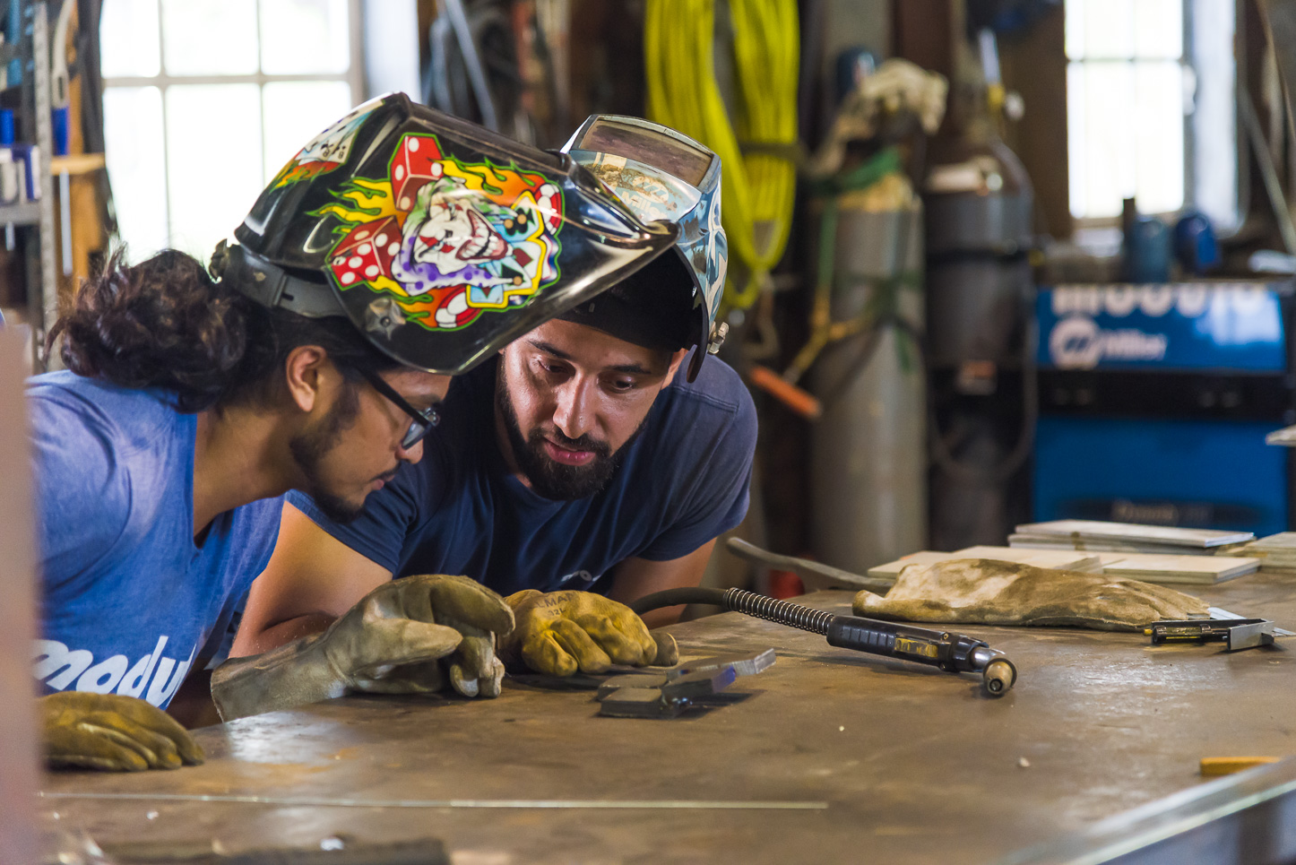 USF architecture alumnus Jesus Lopez teaches wood shop manager Van Lopez how to weld. Photography by Bryce Womeldurf.