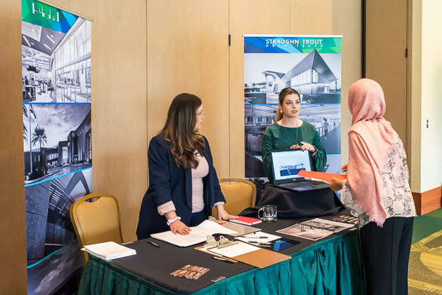 Architect representatives from the Straughn Trout company shake hands with a student