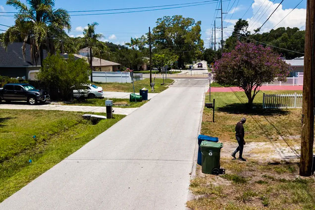 An aerial view on West Gray Street near North Archer Street looking west toward North Himes Avenue, where there are very few large shade trees on July 6 in Tampa. At right, Benjamin Brown heads back to his home after taking his recycling bin out to the curb. [ DIRK SHADD | Times ]