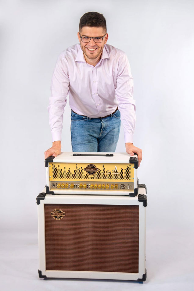 Evgeny Milov standing over amplifiers.