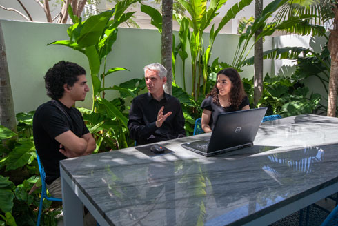 Michael Halflants sitting at a table and teaching students.