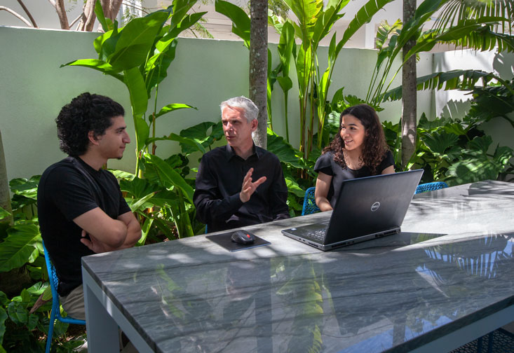 Michael Halflants sitting at a table and teaching students.