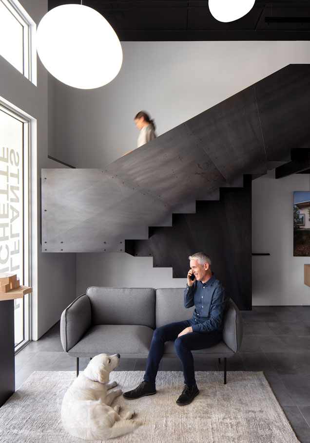 Michael Halflants and his dog, Bear, sit by the stairs.