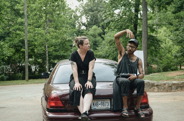Sarah Higgins and artist Jeremy Toussaint-Baptiste in conversation seated on the trunk of a car