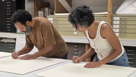 Artist William Villalongo (left) and urbanist Shraddha Ramani (right) signing the First Impressions portfolio