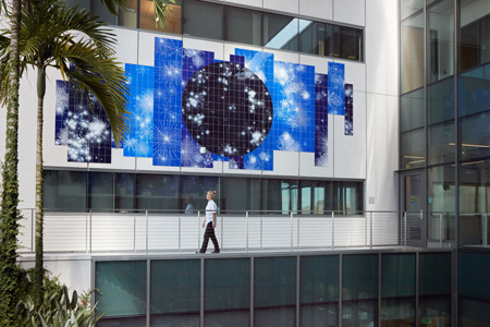 a multicolor exterior mural with a person walking in front of it