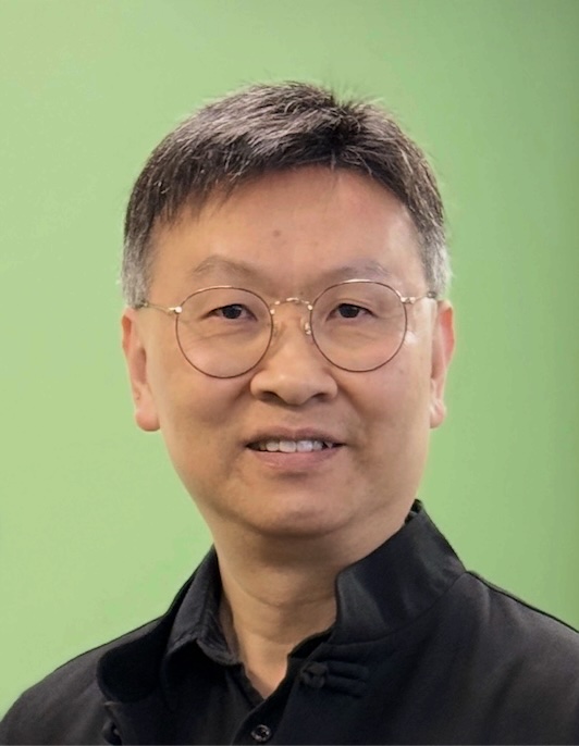 Victor Fung wearing a black shirt with a green background.