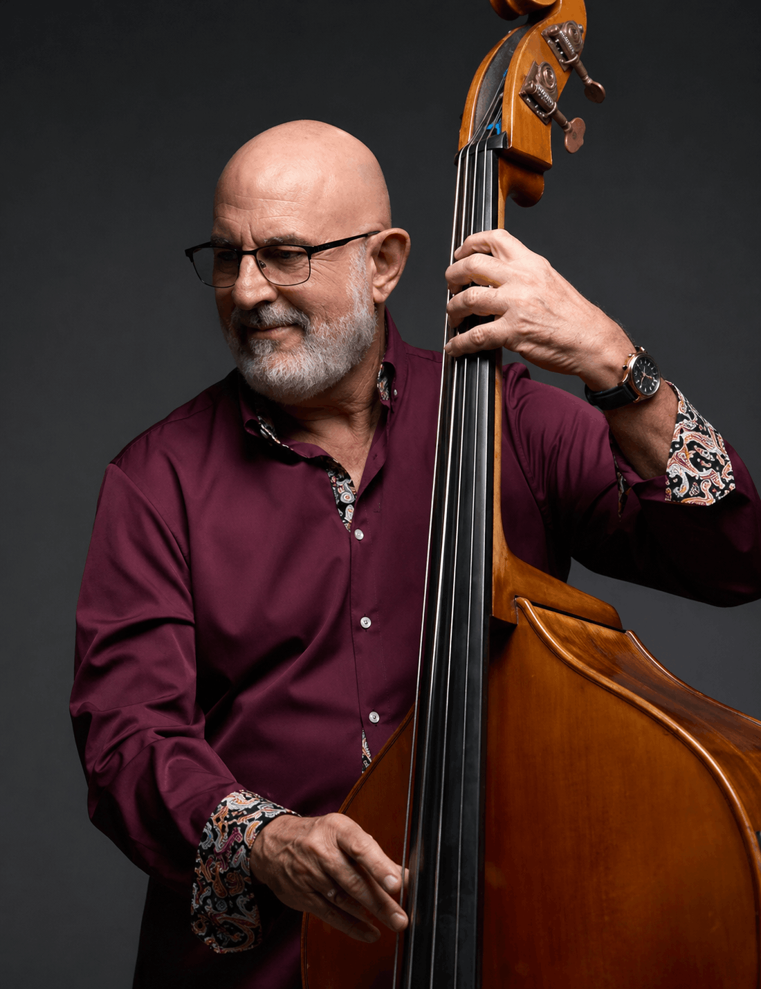 Mauricio Rodriquez wearing a burgundy shirt playing the upright bass