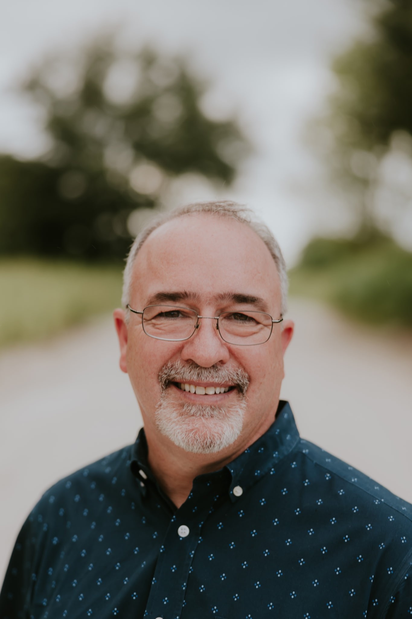 Jeff Cayer wearing glasses and a dark blue patterned collared shirt