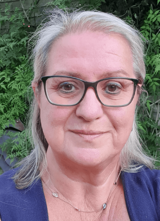 Hara Troulie wearing a blue blouse and glasses