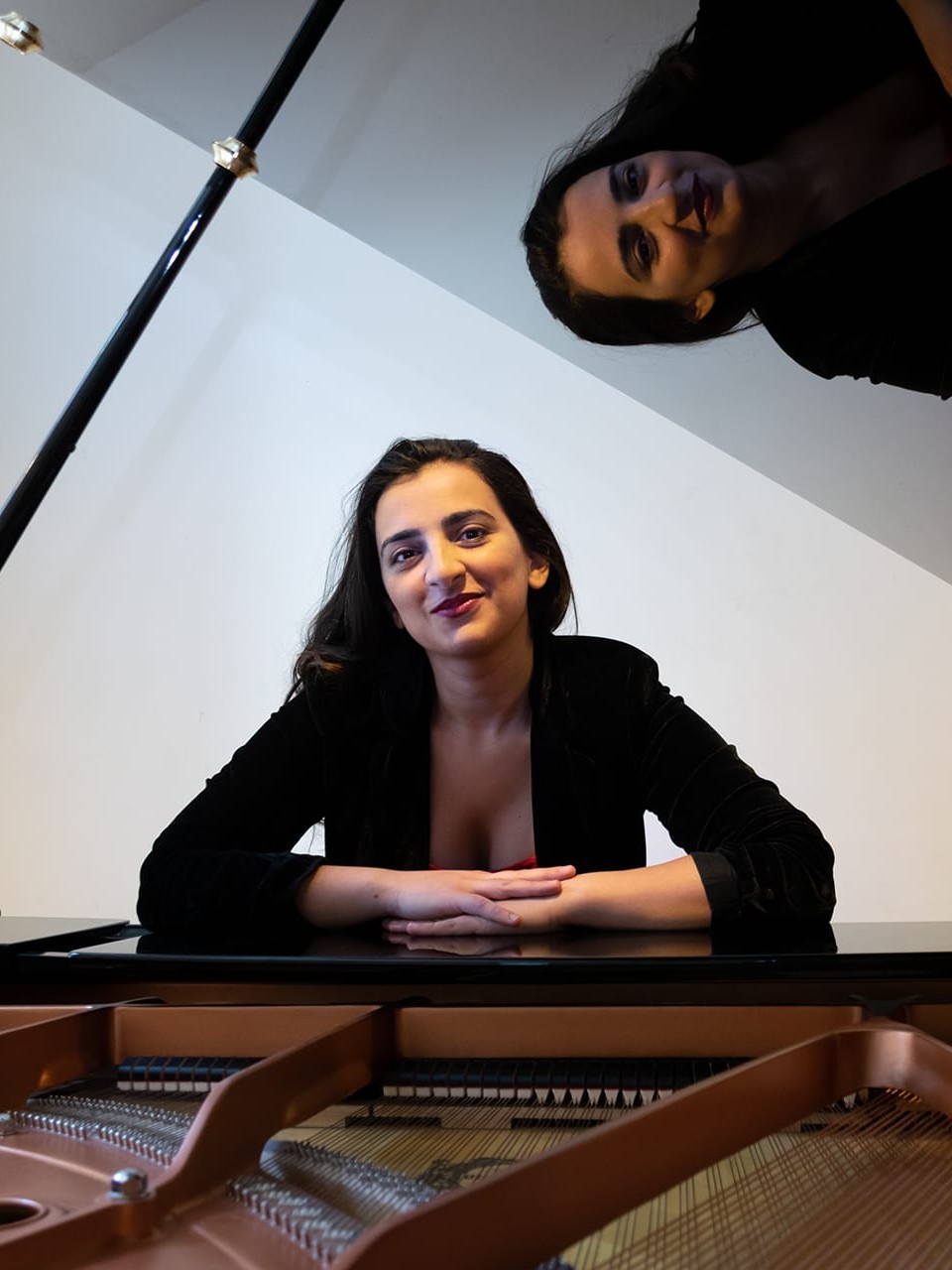 Tinatin Gudadze looking through an open piano lid.