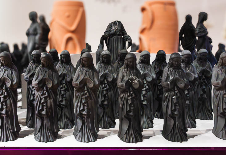 A line of black Virgin of Guadalupe statues, part of a piece by Adrian Gomez, titled Bisagras, 2025