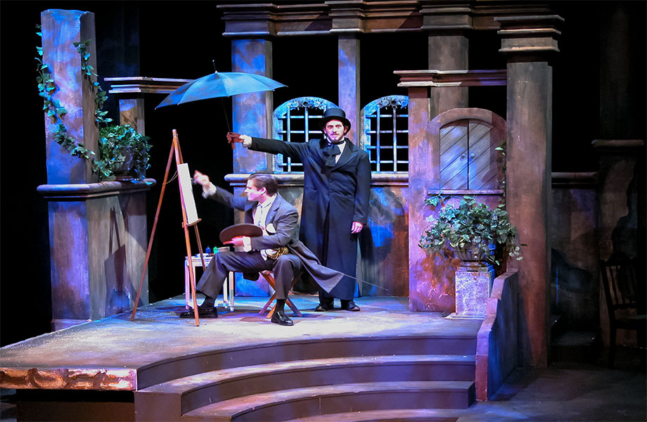 A man in a top hat and trench coat is holding an umbrella over a well-dressed man who is holding his hat while sitting on a stool and painting on a canvas. 